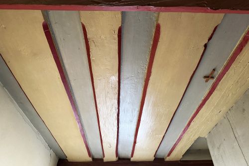 Balken-Bolendecken im 1. OG: Auffällig ist, dass die Balken im Wechsel schmal oder breit sind. Die Zerrbalken sind schmal und die breiten Balken eigentlich dicke Bohlen, die aus mächtigen Stämmen gesägt wurden.