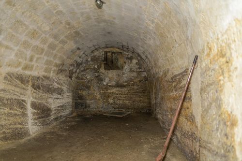 Überwölbter Kellerraum; Boden und Wände: Anstehender Fels mit gut erhaltenen Abspitzungsspuren; Gewölbe aus sorgfältig bearbeiteten Sandsteinquadern