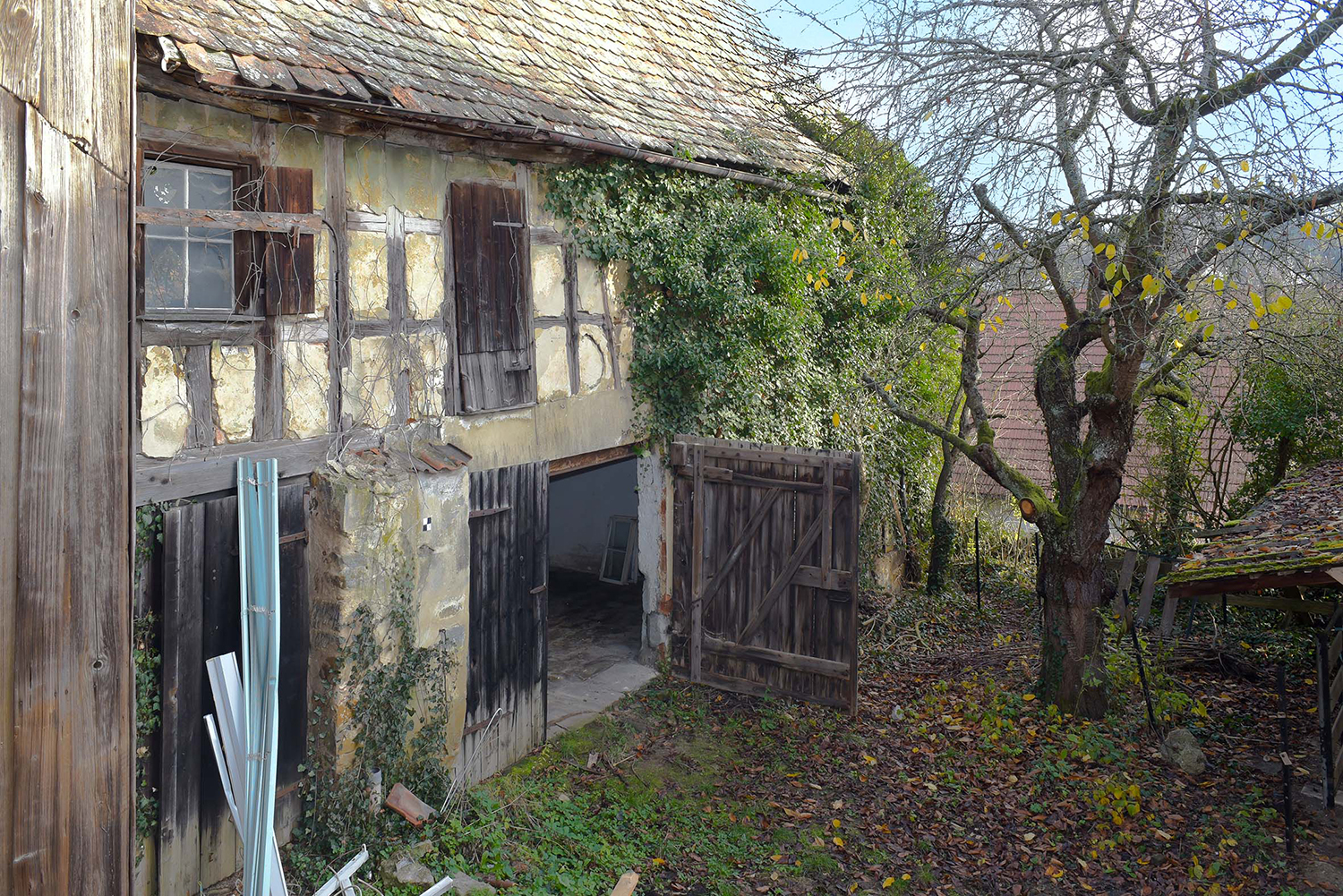 Hofseite der Scheune von 1655 mit Tor zum Garten; Fachwerk hauptsächlich mit Bruchsteinen ausgemauert, teilweise aber auch mit Astgeflecht und Lehm ausgefüllt.